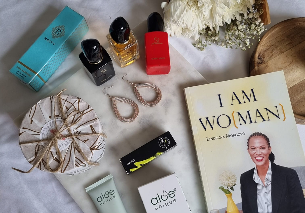 Flat lay of a Black Rose Concepts gift box with a book, perfume and self-care treats
